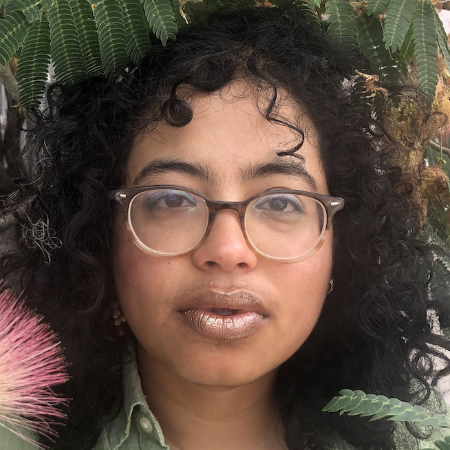 woman with curly brown hair and glasses